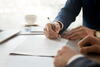 Close up of two people signing a document